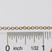 Gold rolo chain next to a ruler to show the size of each loop on the chain.