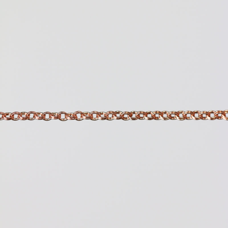 Rose gold double cable chain on a light gray background