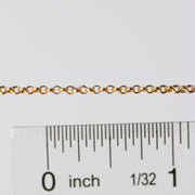 Gold chain next to a ruler on a white background