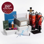 A jewelry making kit displayed on white blocks against a white background, including an Ar mini kit with four red tanks, a mini argon regulator, a blue PJ Toolkit box, a green Chains and Jewelry Supply box, and other accessories. A red circular badge in the top left says 'THIS MONTH ONLY 250" EXTRA CHAIN'.