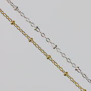 Two cable chains with beads on them. One chain is gold filled yellow and the other is sterling silver