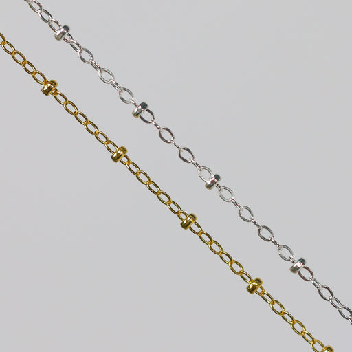 Two cable chains with beads on them. One chain is gold filled yellow and the other is sterling silver