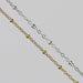 Two cable chains with beads on them. One chain is gold filled yellow and the other is sterling silver