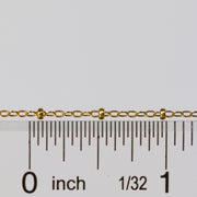 Gold paisley cable chain next to a ruler for measurement