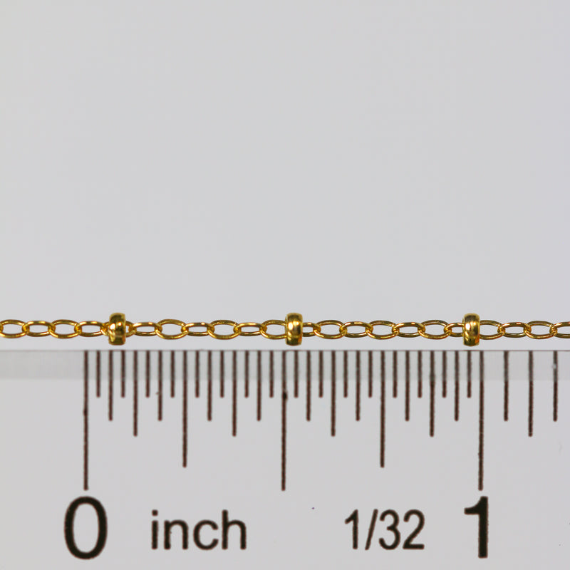 Gold paisley cable chain next to a ruler for measurement