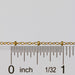 Gold paisley cable chain next to a ruler for measurement