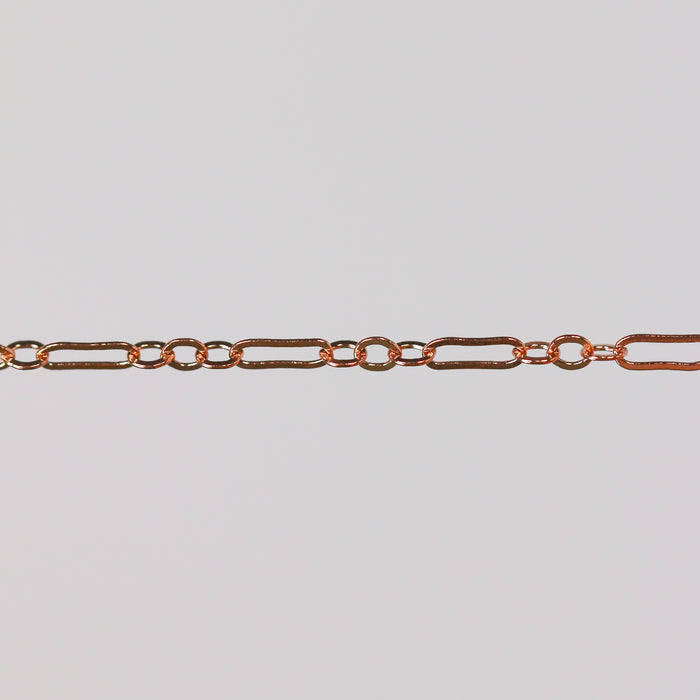 Rose gold paperclip chain on a gray background for permanent jewelry