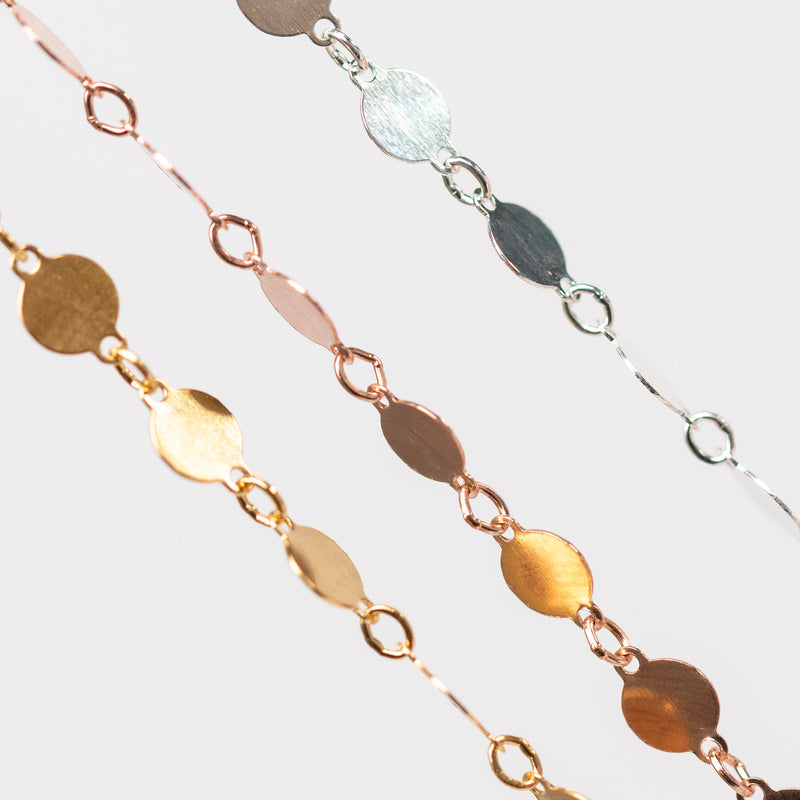 Close-up of a gold and silver chain on a light gray background