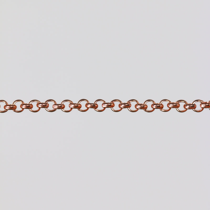Rolo chain in gold filled rose stretched over a gray background to show the links