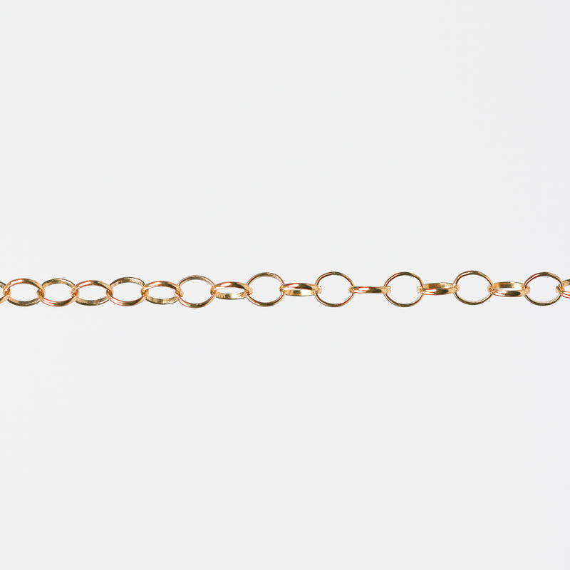 Gold filled yellow chain with round links on a white background