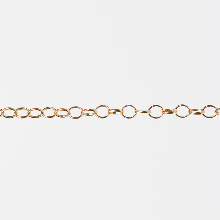 Gold filled yellow chain with round links on a white background