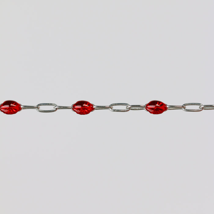 Silver chain bracelet with red enamel on a light gray background