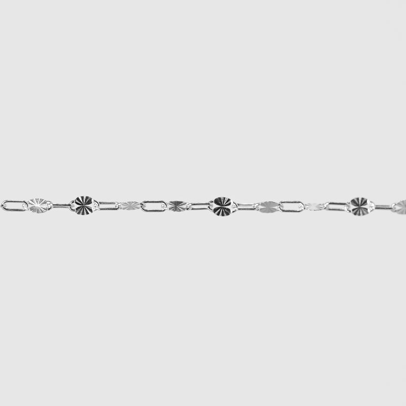 Silver bracelet with decorative links on a light gray background