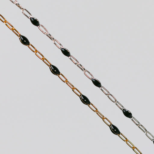 Two gold and silver chains for permanent jewelry with black enamel on a light gray background