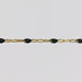 Gold chain with black enamel on a light gray background