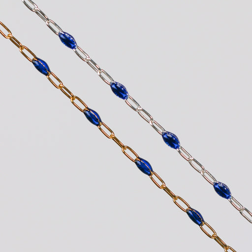Two blue enamel permanent jewelry chains. One chain is yellow gold and the other is silver.