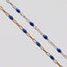 Two blue enamel permanent jewelry chains. One chain is yellow gold and the other is silver.
