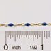 Gold and blue pj chain getting measured with a ruler and showing scale on a white background
