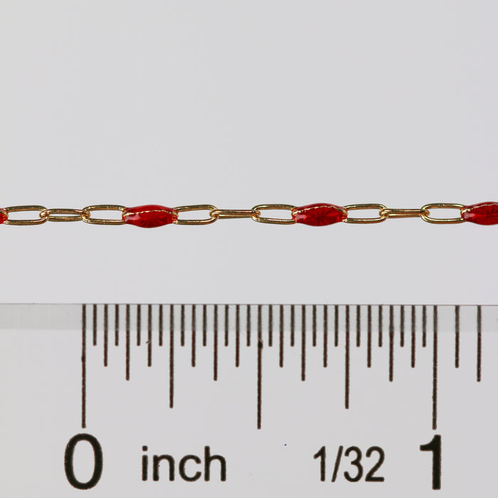 Gold and red chain with a ruler for scale on a white background