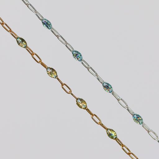 Two gold and silver chains for permanent jewelry with sparkly opal enamel on them on a light gray background