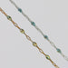Two gold and silver chains for permanent jewelry with sparkly opal enamel on them on a light gray background