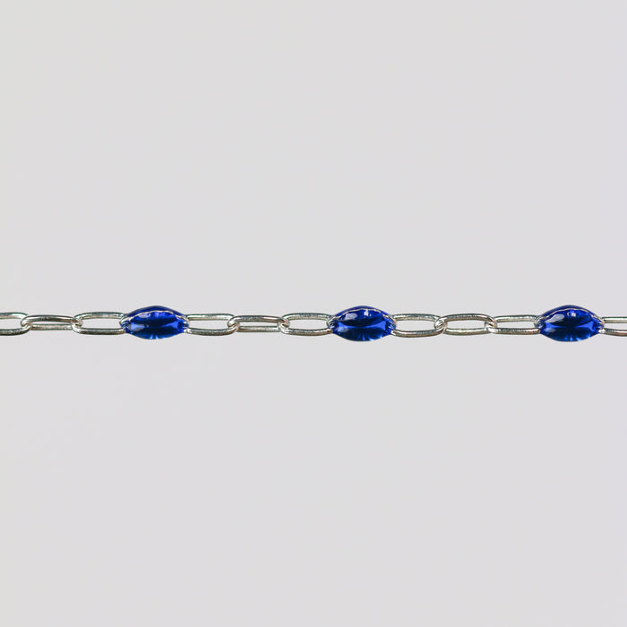 Silver cable chain for permanent jewelry with blue enamel on a light gray background
