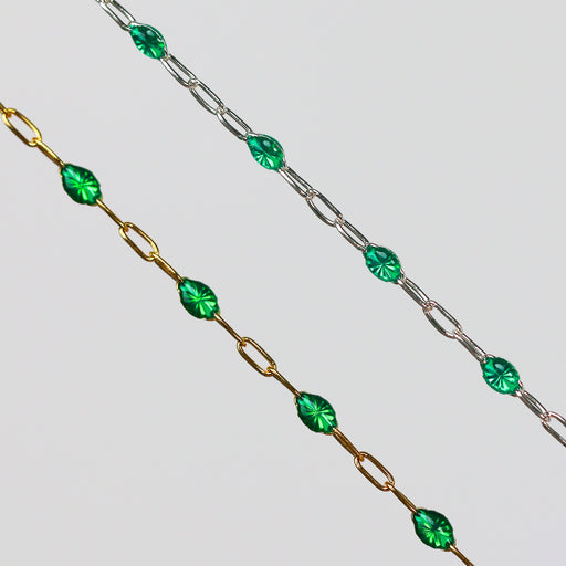 Two gold and silver chains for permanent jewelry with emerald green enamel that sparkles on a light gray background