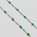 Two gold and silver chains for permanent jewelry with emerald green enamel that sparkles on a light gray background