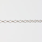 Silver chain for permanent jewelry making on a gray background
