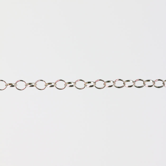 Silver chain for permanent jewelry making on a gray background
