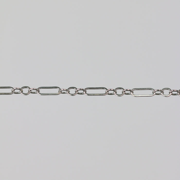 Sterling silver permanent jewelry chain on a gray background