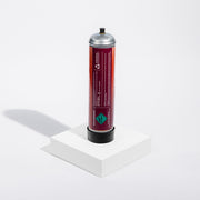 Cylindrical argon gas container with a red label on a white background standing on a white platform with a gray colored shadow