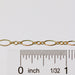 Gold chain with a ruler for scale on a white background