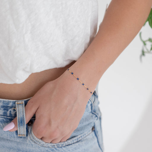 Person wearing an enamel permanent bracelet on a blurred background
