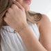 Close-up of a person wearing a fine permanent jewelry chain with a blurred background