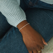 Hand wearing a paperclip bracelet with a blurred background