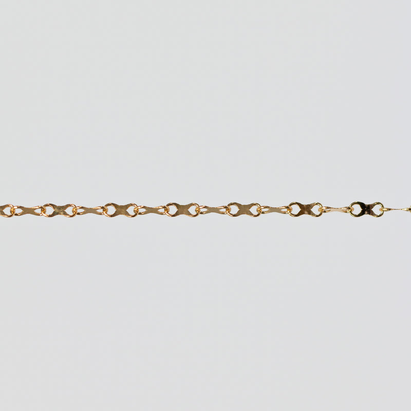 Gold chain with concave infinity symbol links on a light gray background