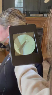 Video of a customer getting a permanent jewelry necklace welded on through the Sunstone Halo darkening lens on it's articulating arm.